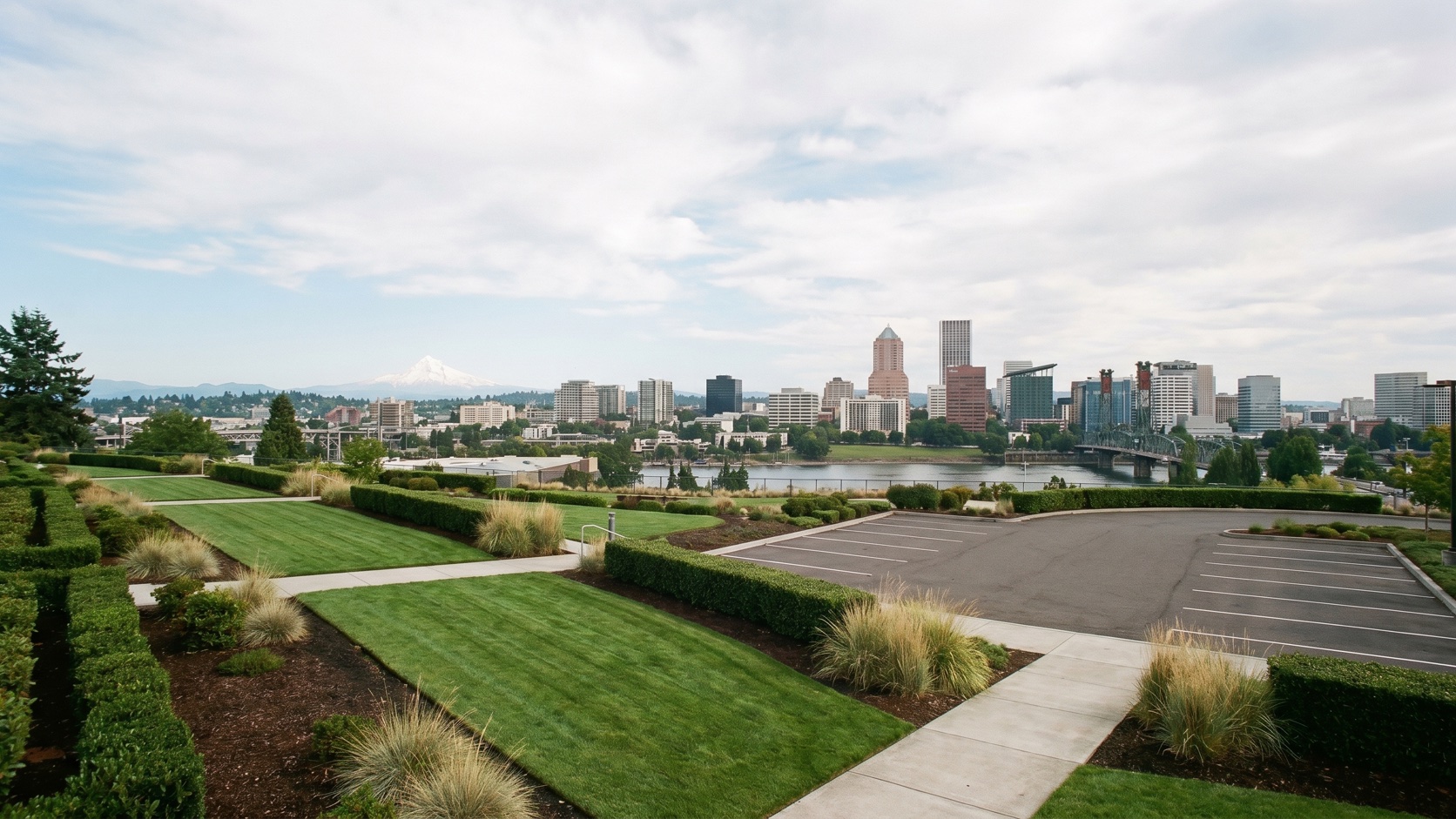 Manicured commercial property landscaping with the downtown Portland skyline and Mount Hood beyond at golden hour
